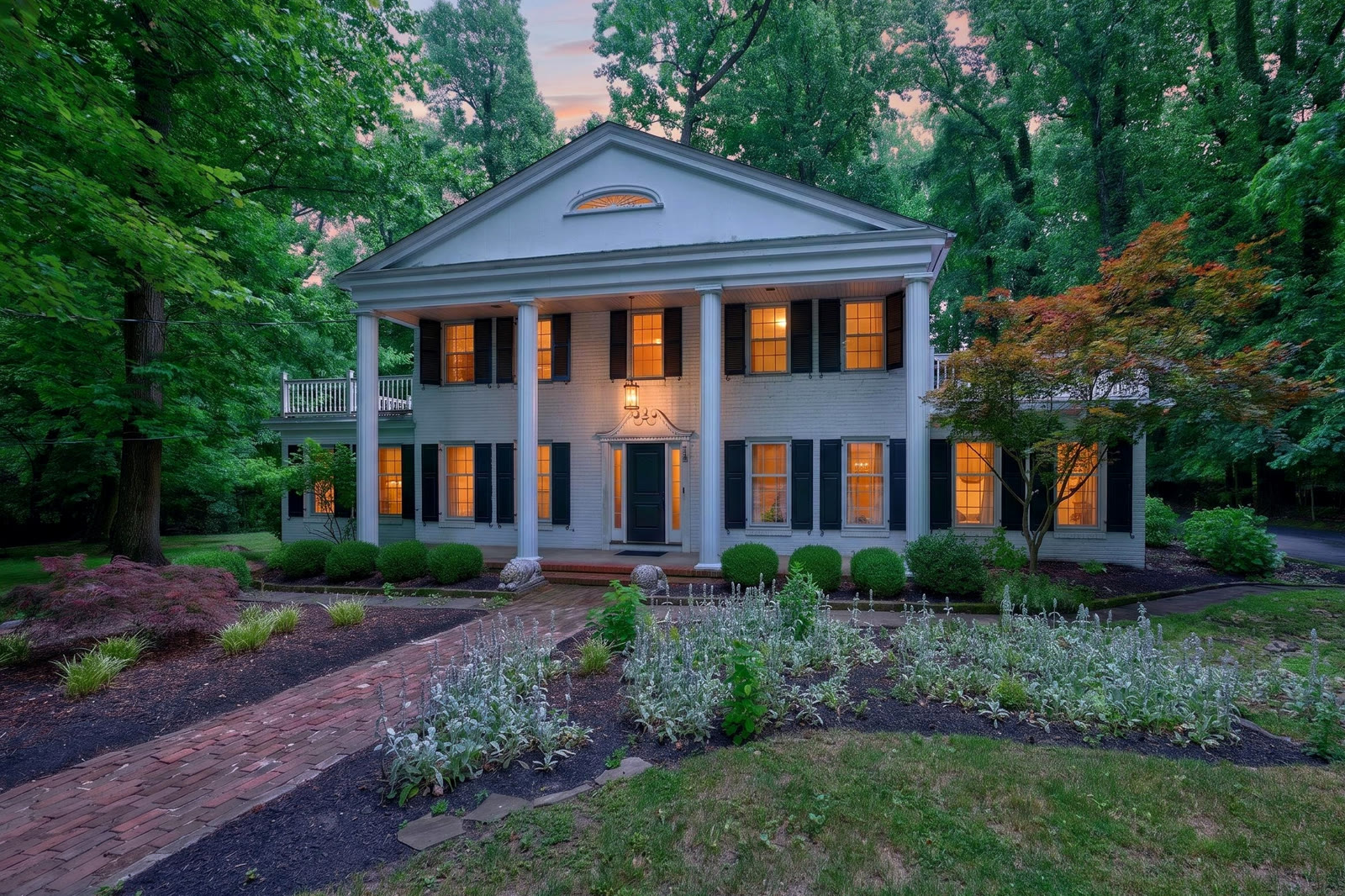 Benson's Bayou at dusk — a stately columned home, windows lit