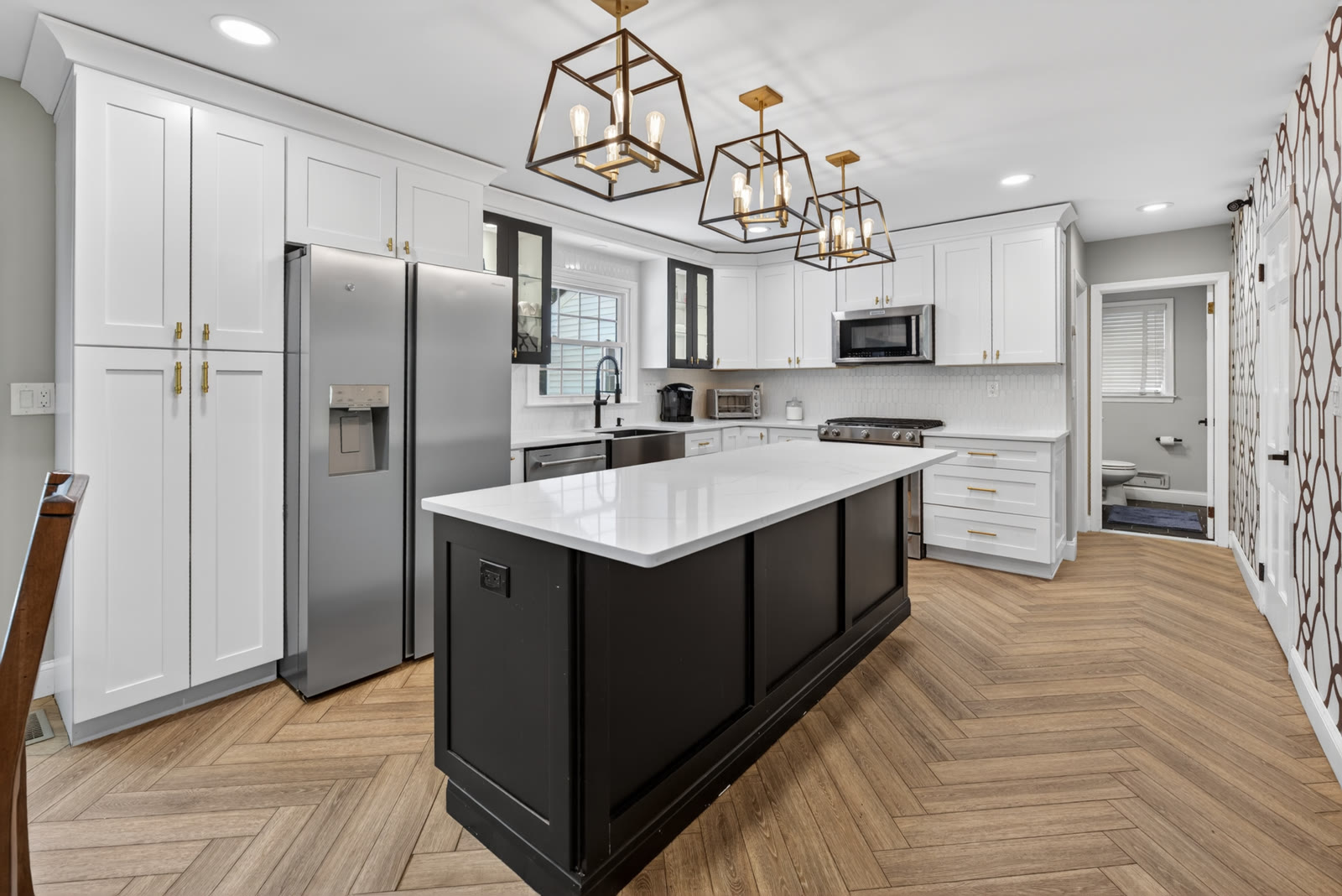 Renovated kitchen with a big island and lantern pendants