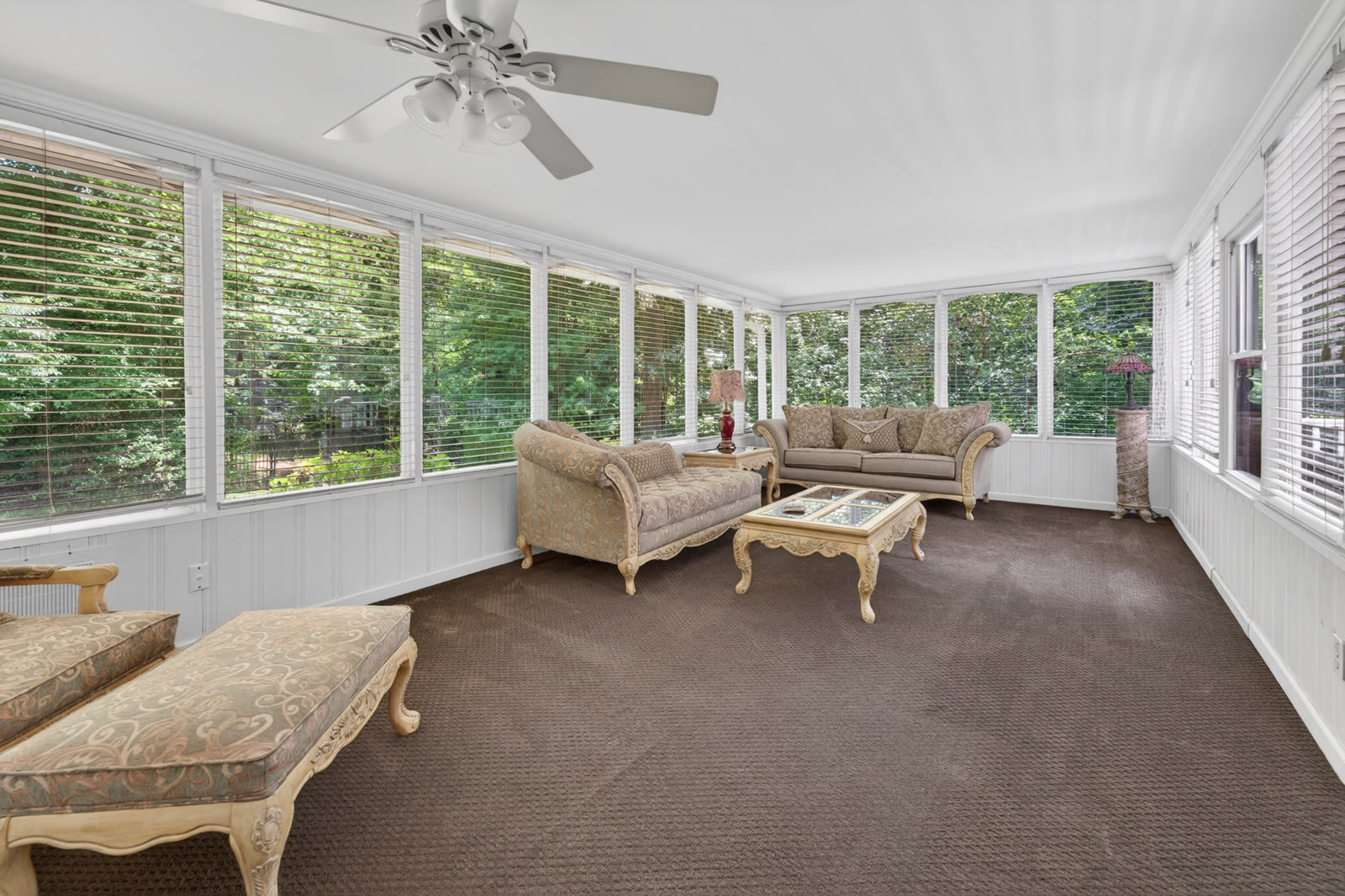 Sunroom with walls of windows onto the trees