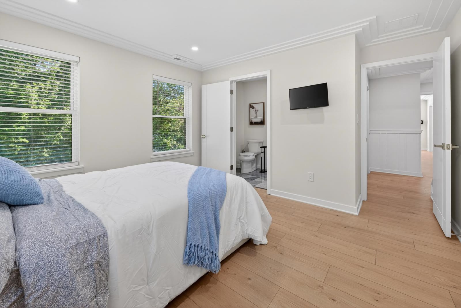 A calm, comfortable resident bedroom with tree-lined views